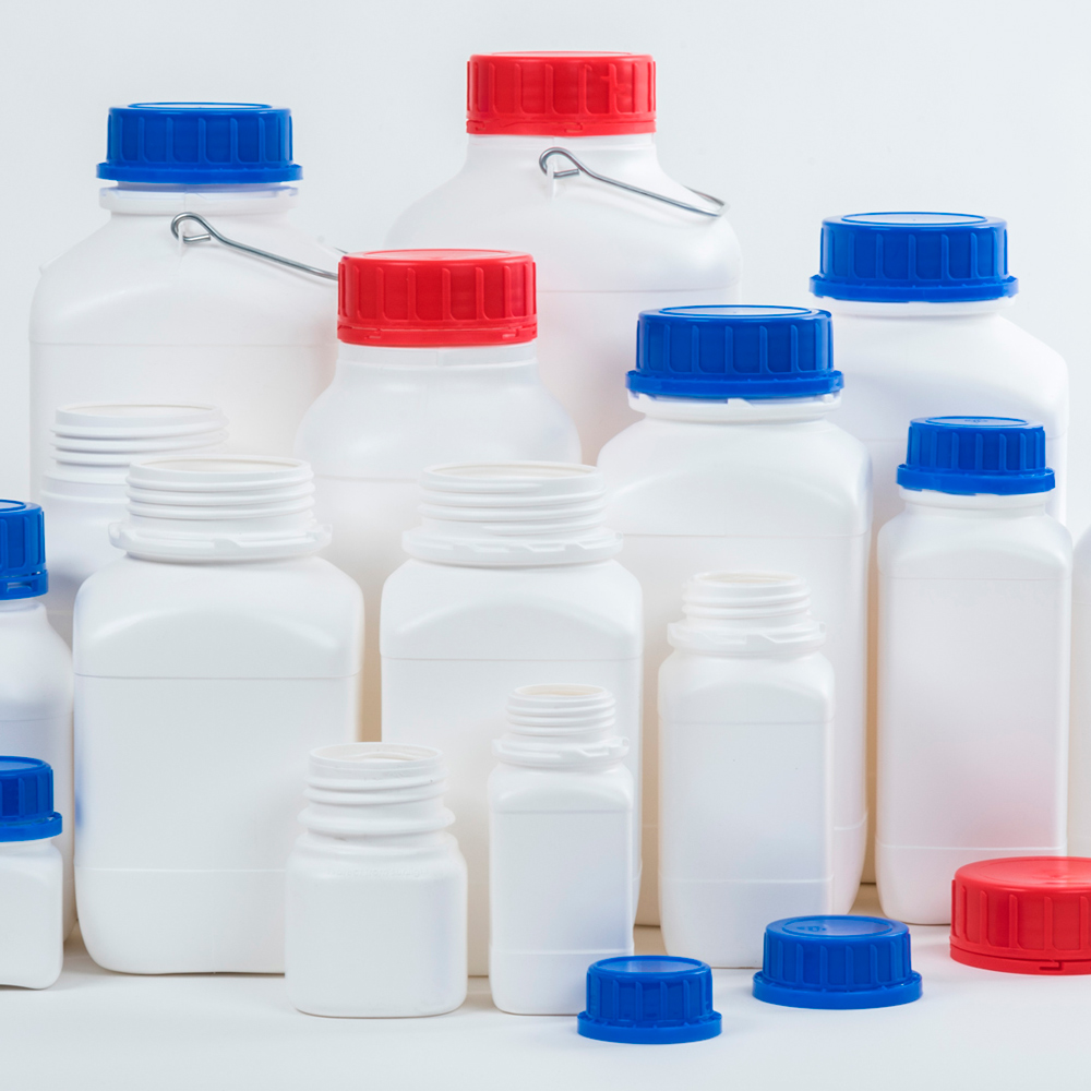 Kunststoff-Weithalsflaschen in quadratischer Bauform mit verschiedenen Varianten von Verschraubungen in Rot und Blau